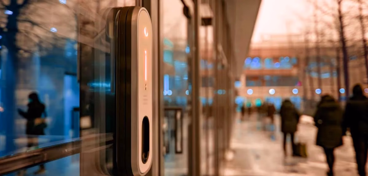 Puerta automática en exterior con sensor de proximidad y control de acceso.
