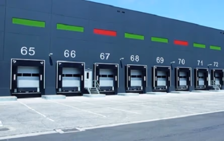 Puertas enrollables en almacén con numeración 65 a 72.