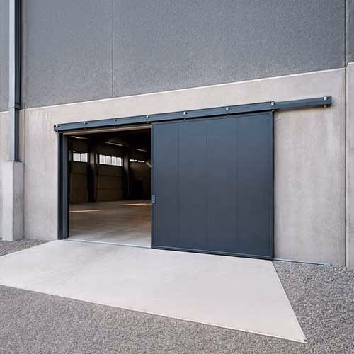 Puerta corredera industrial metálica instalada en una nave